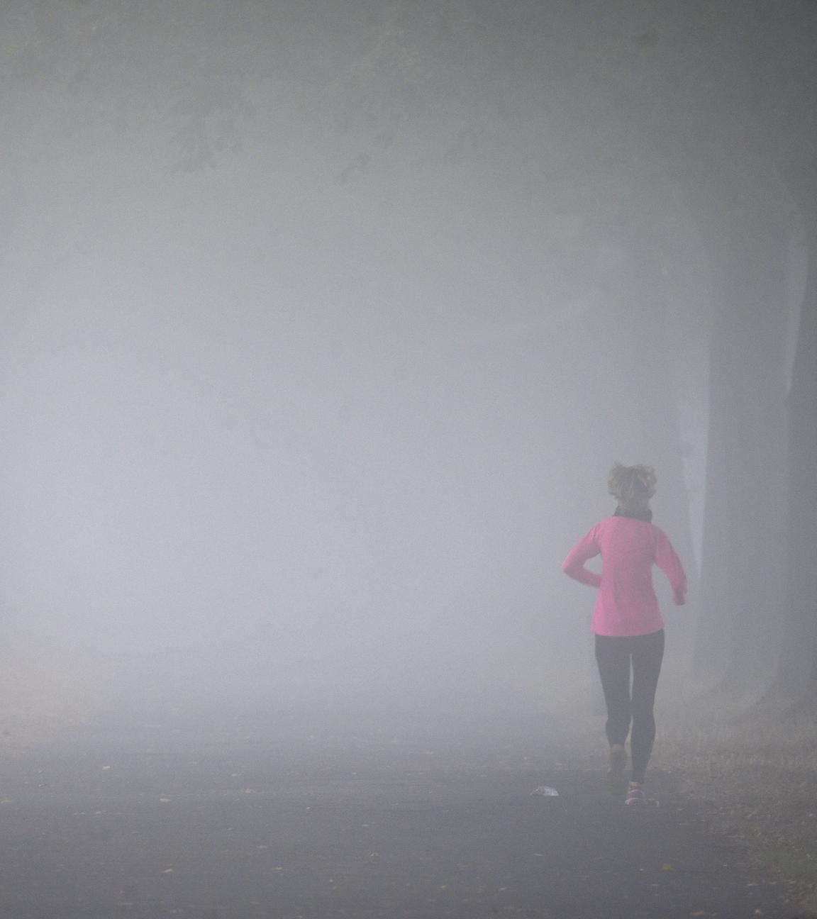 Archiv: Eine Frau joggt im Nebel