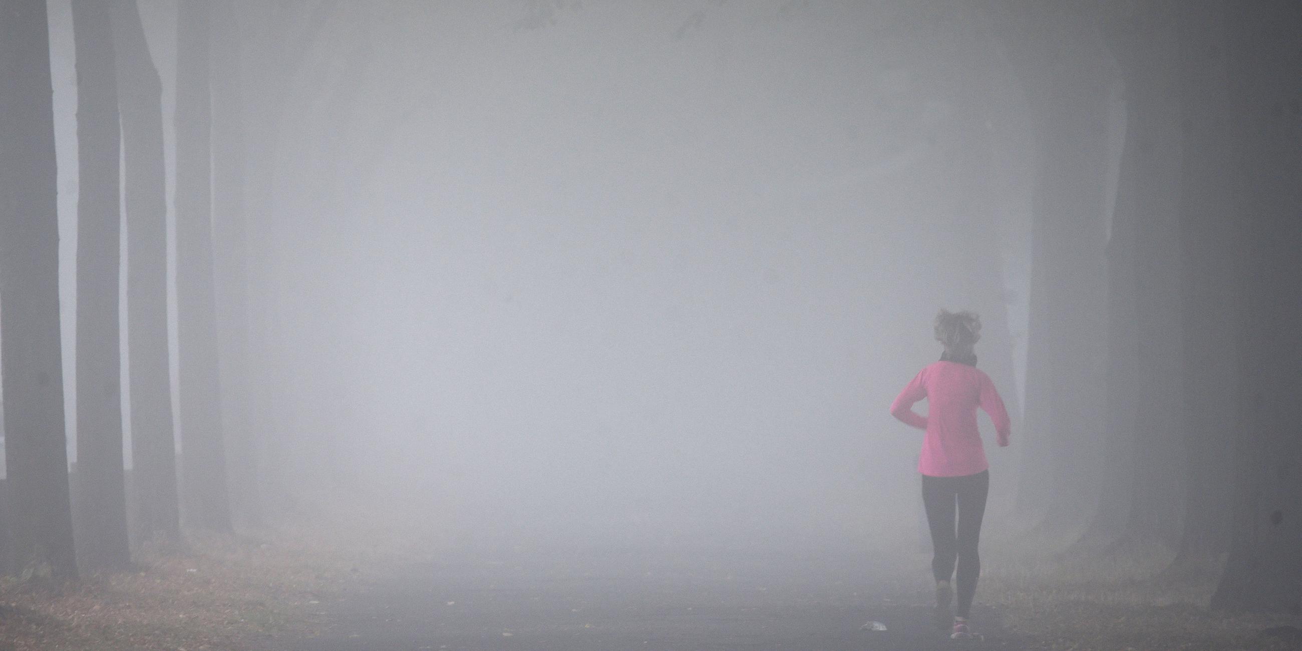 Archiv: Eine Frau joggt im Nebel