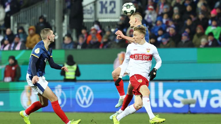 Im DFB-Pokal Viertelfinale kann sich Holstein Kiels Innenverteidiger Ivan Nekic im Zweikampf mit Stuttgarts Flügelspieler Chris Führich per Kopfball durchsetzen