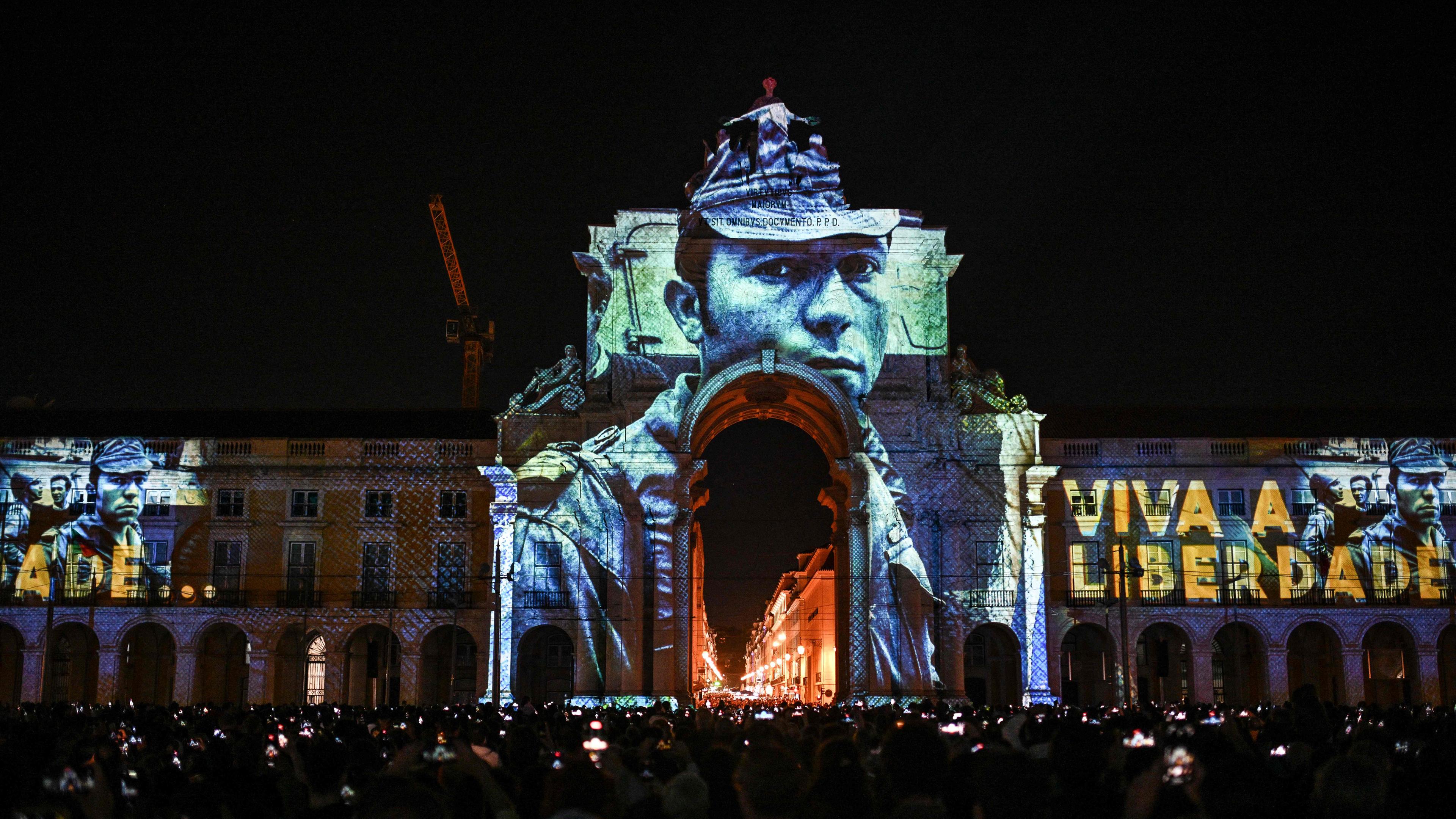 Die Projektion des Bildes eines Soldaten auf einen Bogen am Comercio Platz in Lissabon, Portugal zu den Feierlichkeiten 50 Jahre Nelkenrevolution.