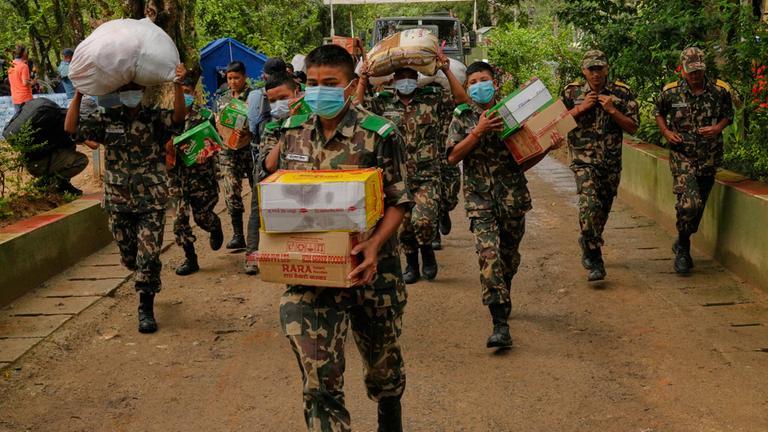 Soldaten der nepalesischen Armee transportieren Hilfsgüter für die Überlebenden der Sturzflut im Distrikt Nuwakot in Nepal.
