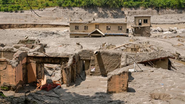 Zerstörte Gebäude sind nach der Sturzflut im nepalesischen Distrikt Nuwakot zu sehen.