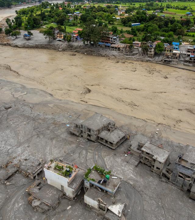 Vogelperspektive auf eine von der Flut zerstörte Siedlung in Nepal. 