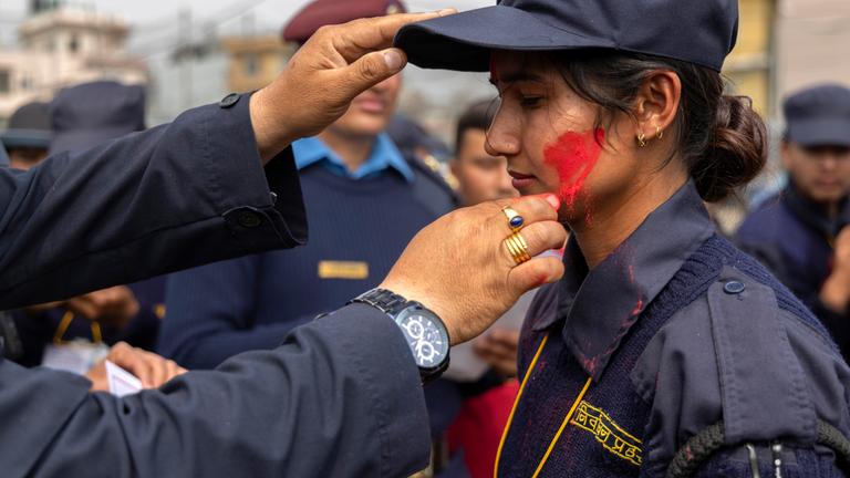 Ein nepalesisches Mitglied der temporären Wahlpolizei reagiert während ihrer Abschiedszeremonie nach der Parlamentswahl in Kathmandu