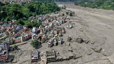Nach Sturzfluten in Trishuli Bazar im nepalesischen Distrikt Nuwakot stehen Häuser am Flussufer teilweise im schlammigen Wasser.
