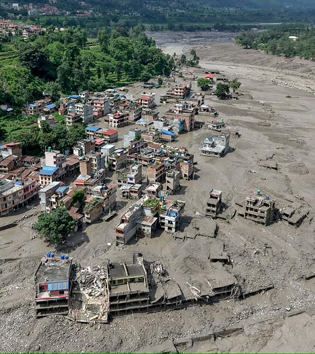 Nach Sturzfluten in Trishuli Bazar im nepalesischen Distrikt Nuwakot stehen Häuser am Flussufer teilweise im schlammigen Wasser.