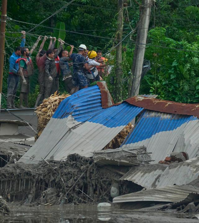  Rettungskräfte spannen ein Seil, um nach Überlebenden zu suchen, nachdem es im Bezirk Nuwakot in Nepal zu Sturzfluten entlang des Trishuli-Flusses gekommen war.