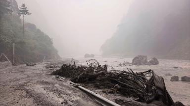 Schlammiges Flussufer mit Trümmern in der Nähe des Hafens von Gyirong in der Autonomen Region Tibet im Südwesten Chinas.