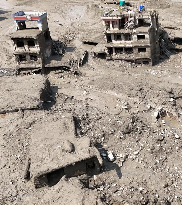 Beschädigte Gebäude und Infrastruktur entlang des angeschwollenen Trishuli-Flusses nach einer massiven Sturzflut. 