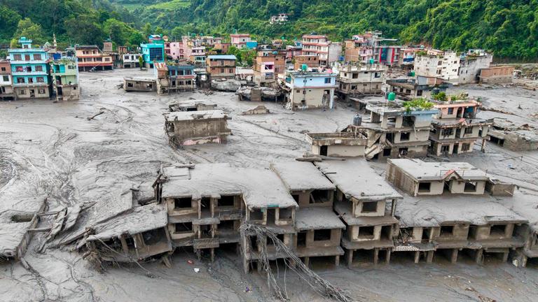 Eine Luftaufnahme zeigt Häuser, die nach Sturzfluten in Devighat (Gemeinde Bidur im nepalesischen Distrikt Nuwakot) am 27. 08. 2026 von Schlamm überflutet sind. 