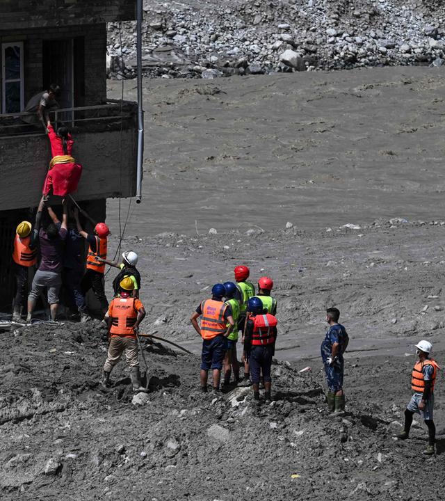 Polizeikräfte retten am 27. August 2026 im nepalesischen Distrikt Nuwakot (Trishuli) eingeschlossene Bewohner aus einem von Schlamm verschütteten Haus. 