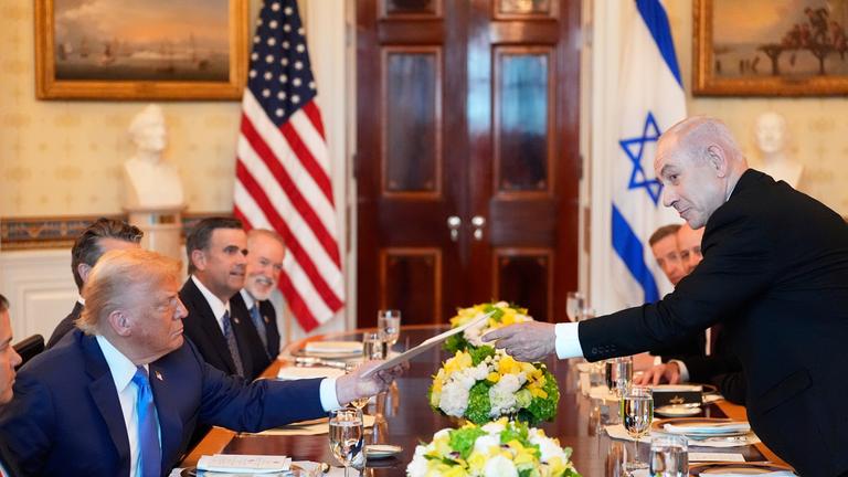 Benjamin Netanjahu (r), Ministerpräsident von Israel, überreicht US-Präsident Donald Trump eine Mappe während eines Treffens im Blue Room des Weißen Hauses in Washington.