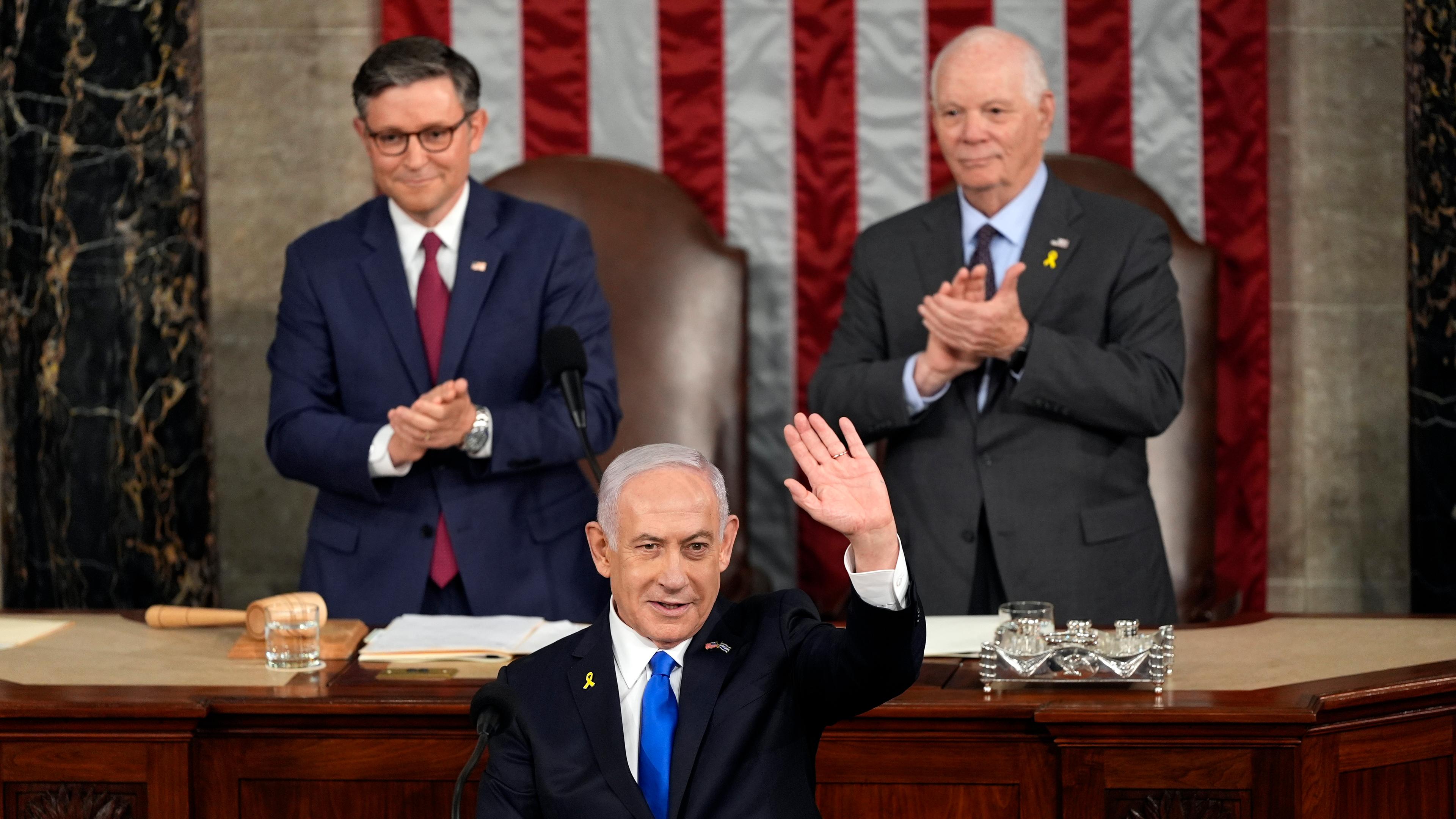 24.07.2024, USA, Washington: Der israelische Ministerpräsident Benjamin Netanjahu winkt nach seiner Rede im US-Kongress, während der Sprecher des Repräsentantenhauses, Mike Johnson (l), und der Vorsitzende des Senats für auswärtige Beziehungen, Ben Cardin (r), applaudieren.