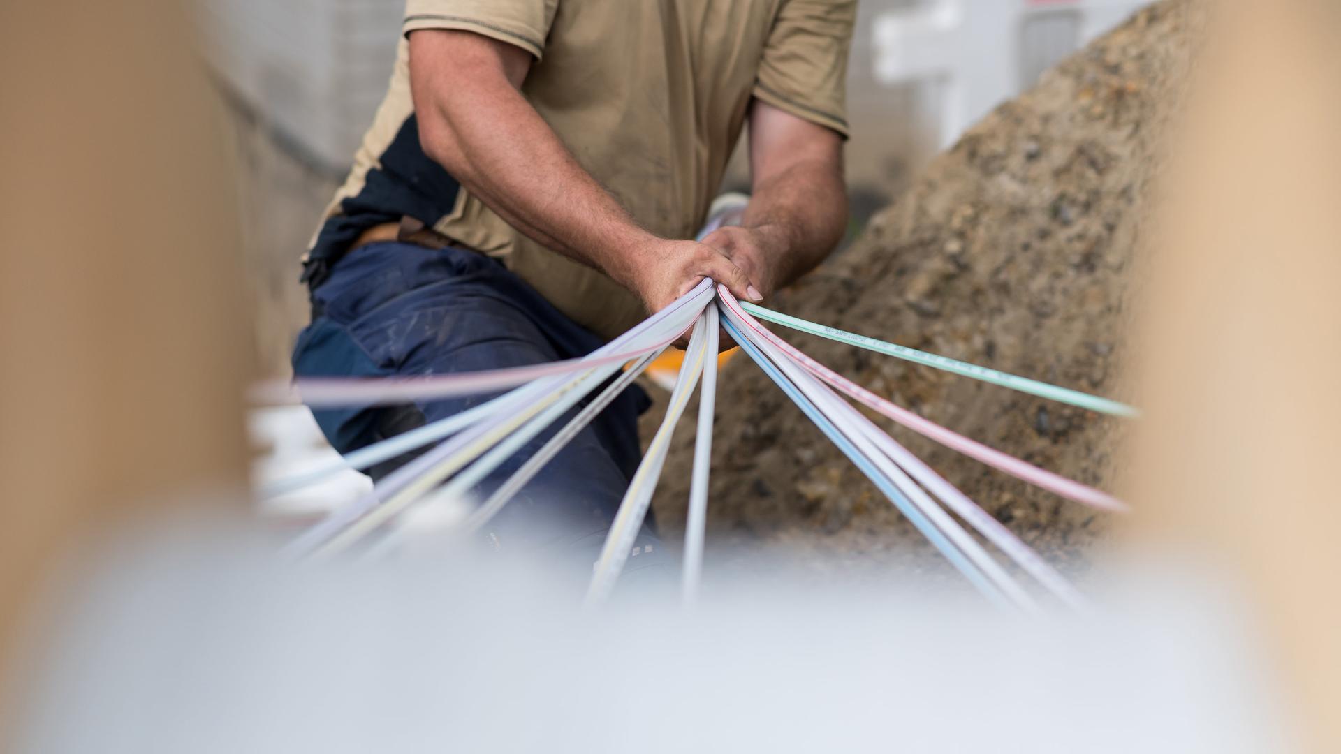 Am Netzausbau wird schon gearbeitet: Ein Mitarbeiter einer Erdbaufirma bündelt Glasfaser-Leerrohre.