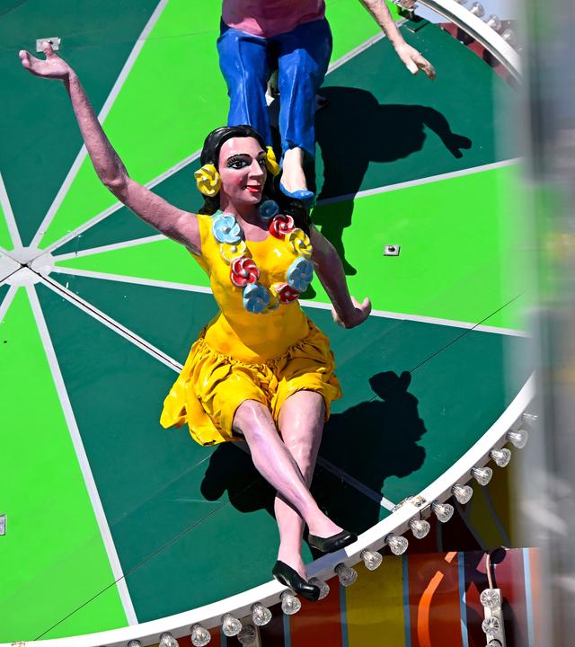 Neu gestaltete Frauenfiguren sitzen auf dem Oktoberfestgelände über dem Eingang am Teufelsrad, am 31.08.2026. in München, Bayern.