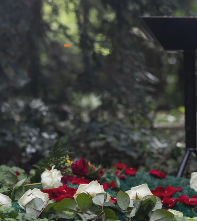 Ein Grab mit Kreuz und Rosen
