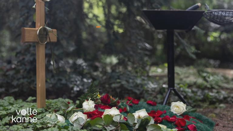 Ein Grab mit Kreuz und Rosen