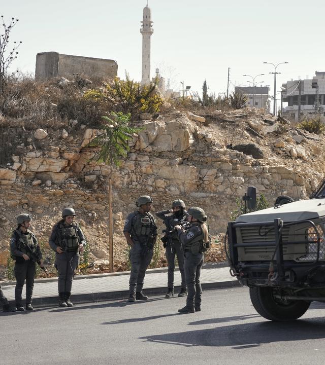 Israelische Soldaten versammeln sich am Ort eines Schussangriffs, den palästinensische Bewaffnete an einer Kreuzung in der Nähe von Hebron im besetzten Westjordanland verübt haben.