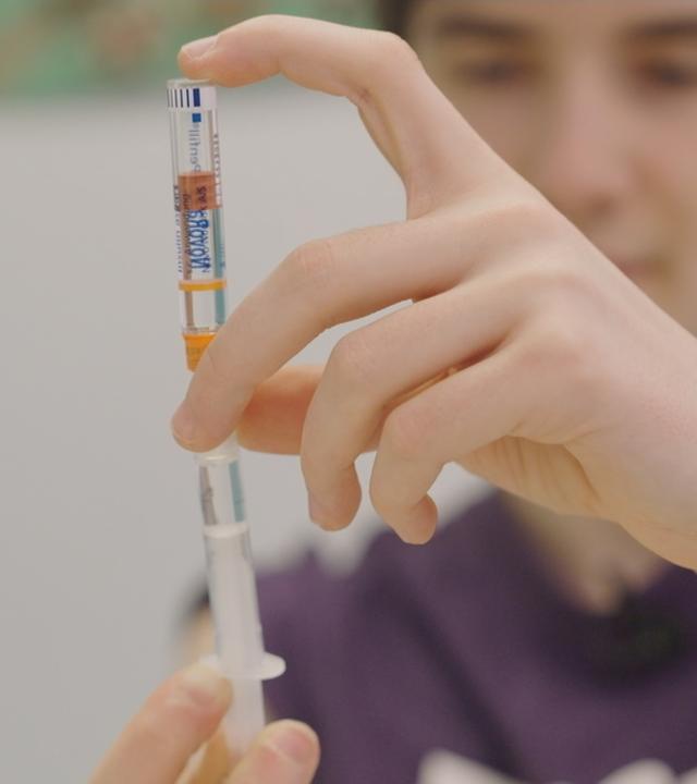 Junge bereitet eine Spritze vor.