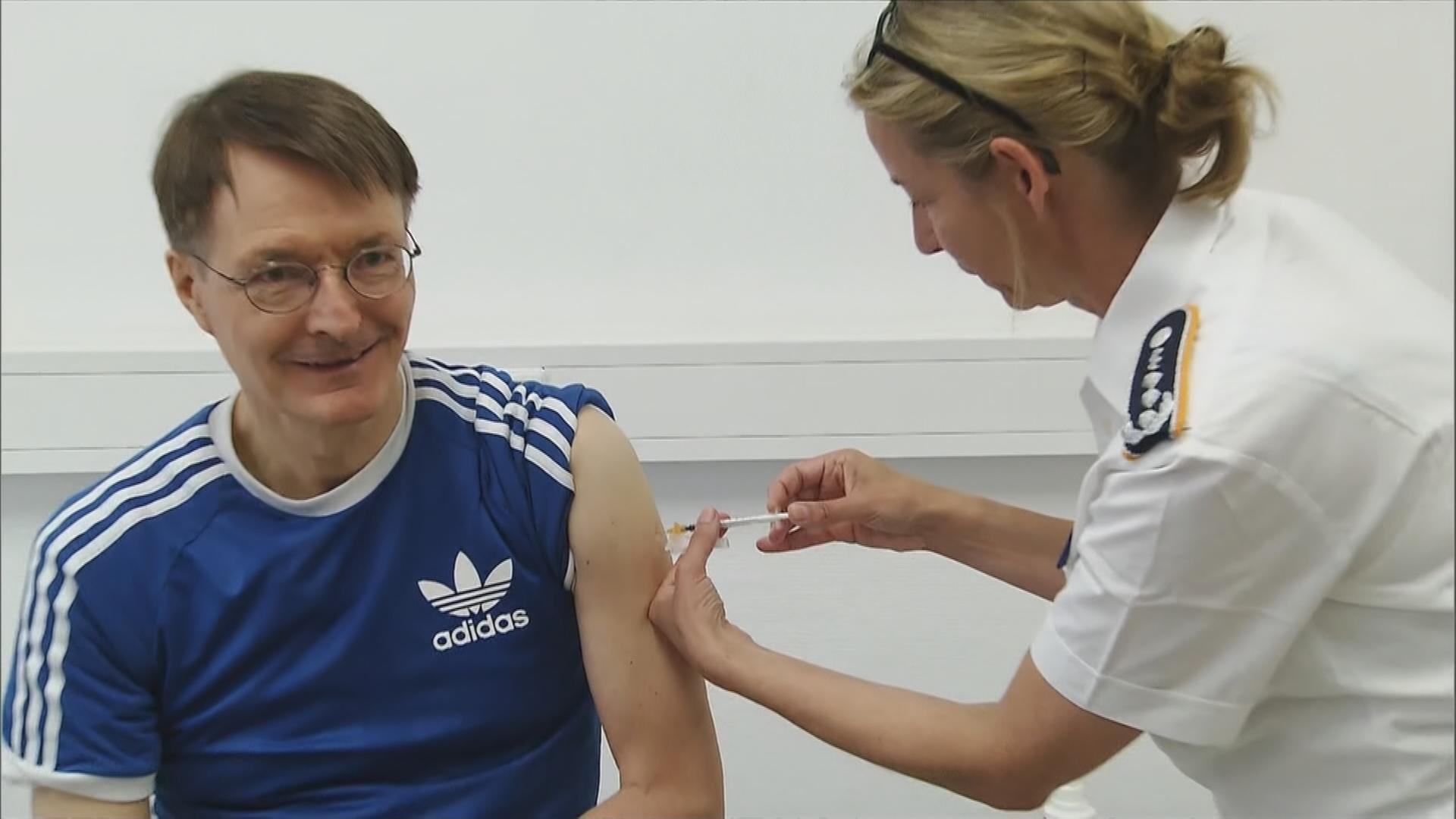 Karl Lauterbach wird von Ärztin mit neuem Coronaimpfstoff geimpft.