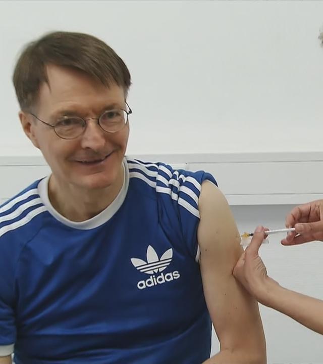 Karl Lauterbach wird von Ärztin mit neuem Coronaimpfstoff geimpft.