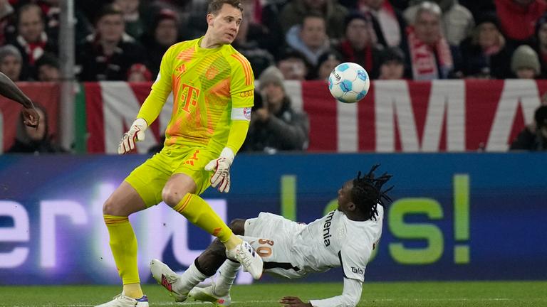 Bayer Leverkusens Jeremie Frimpong geht zu Boden, nachdem er von Bayern-Keeper Manuel Neuer gecheckt wurde.