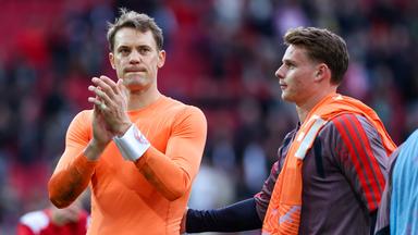 Bayerns Keeper Manuel Neuer wird nach der Bundesligapartie gegen den FC Augsburg von seinem Teamkameraden Jonas Urbig aufgemuntert