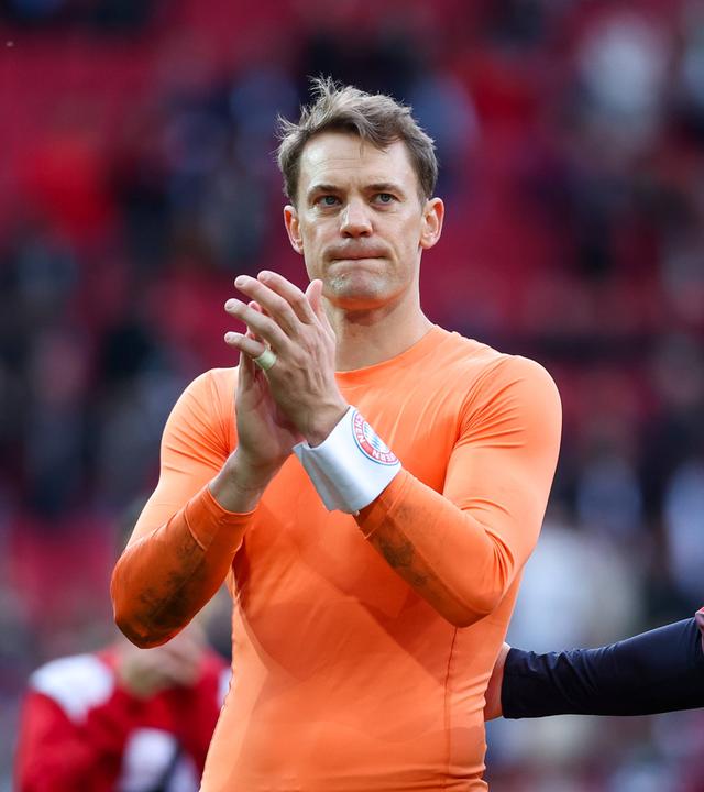 Bayerns Keeper Manuel Neuer wird nach der Bundesligapartie gegen den FC Augsburg von seinem Teamkameraden Jonas Urbig aufgemuntert