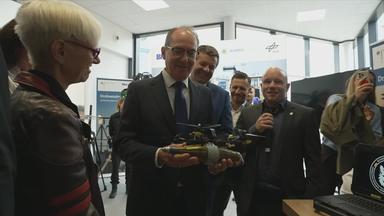 Innenminister Dobrindt bei der Eröffnung des Forschungszentrums mit einer Drohne in der Hand.