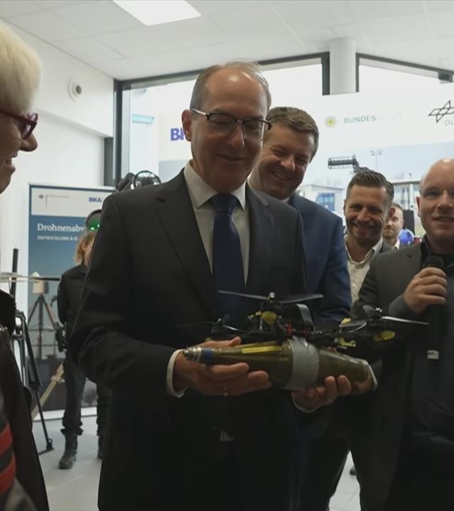Innenminister Dobrindt bei der Eröffnung des Forschungszentrums mit einer Drohne in der Hand.