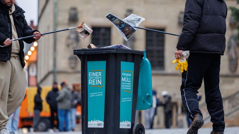 Junge Muslime sammeln Müll in Mülltonnen am 01.01.2026 vor dem Osnabrücker Rathaus beim traditionellen Neujahrsputz.