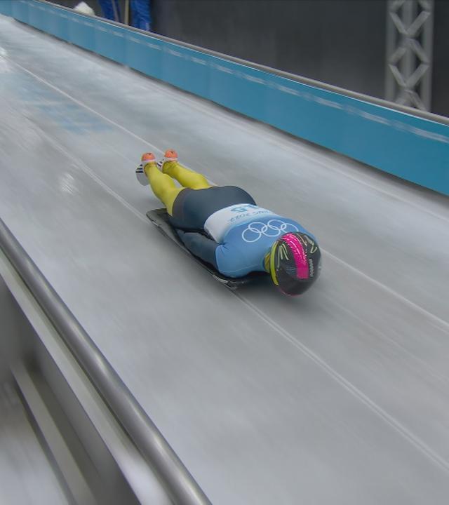 Ein russischer Rodler rodelt unter neutraler Flagge durchen den Eiskanal