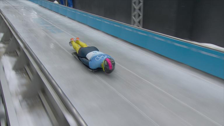 Ein russischer Rodler rodelt unter neutraler Flagge durchen den Eiskanal