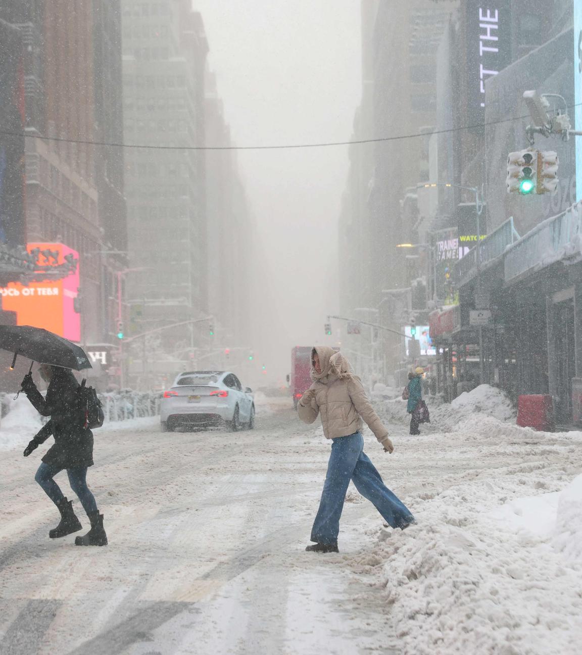 Menschen während des Schneesturms am Times Square in New York am 23.02.2026