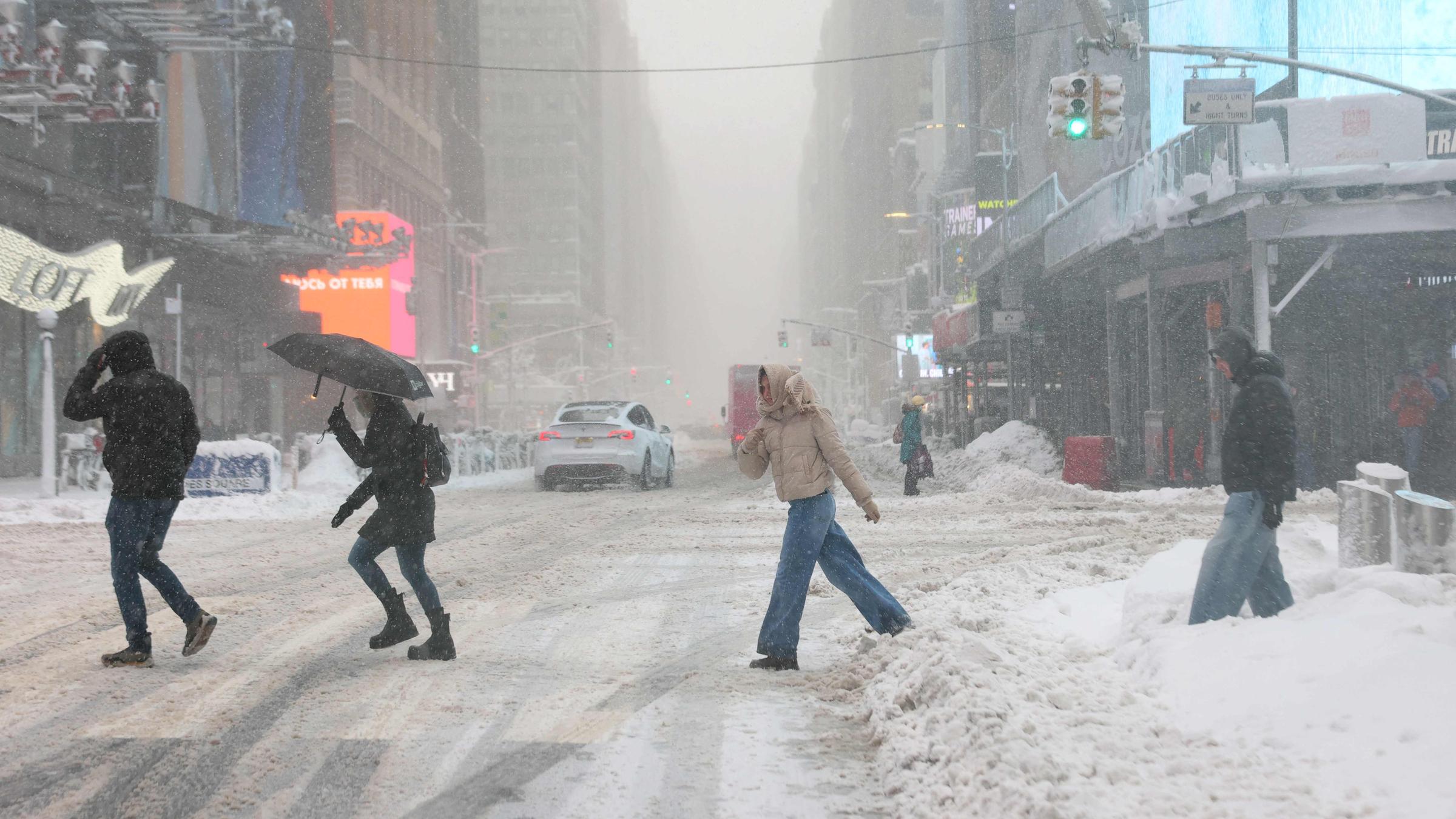 Menschen während des Schneesturms am Times Square in New York am 23.02.2026