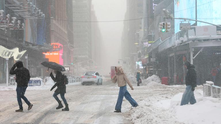 Menschen während des Schneesturms am Times Square in New York am 23.02.2026