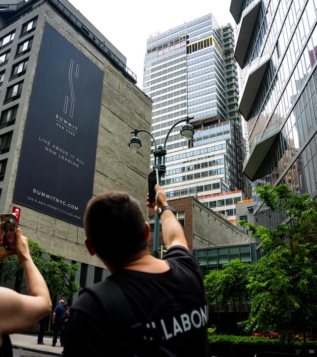 Menschen beobachten das instabile Gebäude in der 235 East 42nd Street in New York 