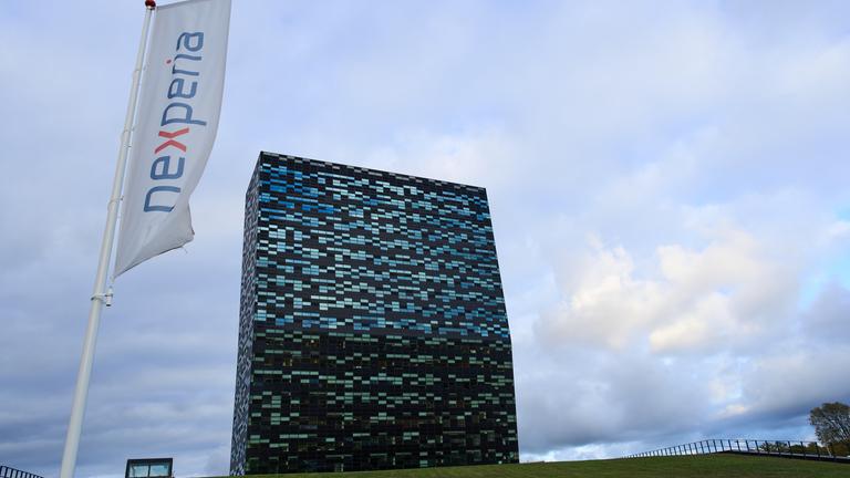 Eine Flagge mit dem Nexperia ist zu sehen und im Hintergrund sieht man den Standort der Firma.