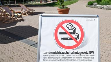 Baden-Württemberg, Stuttgart: Ein Hinweisschild mit Rauchverbot-Symbol informiert in einem Freibad über das "Landesnichtraucherschutzgesetz BW" und ein Rauchverbot auf dem Gelände.