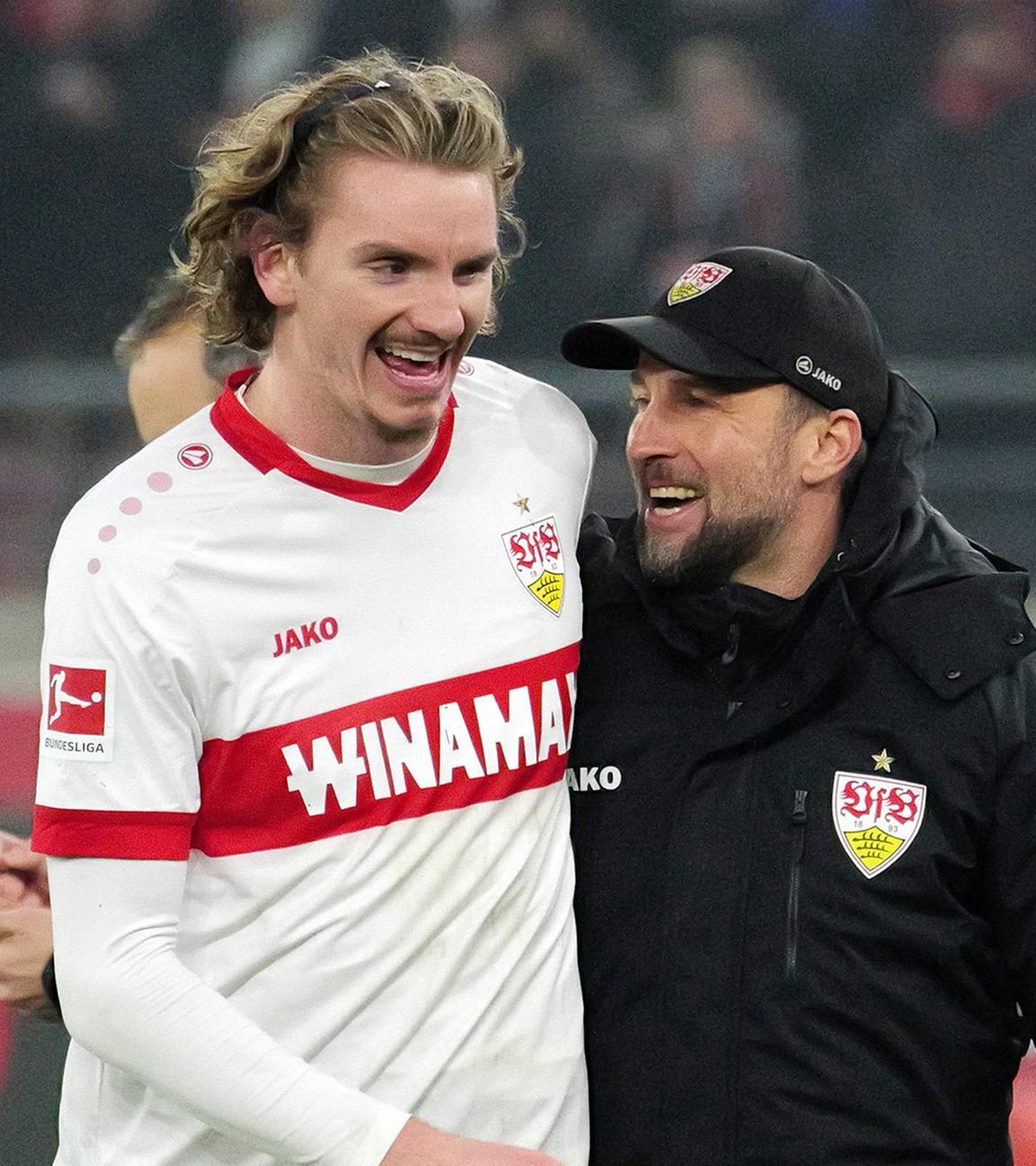 Nick Woltemade und der VfB Stuttgart Trainer Sebastian Hoeneß laufen über das Spielfeld.