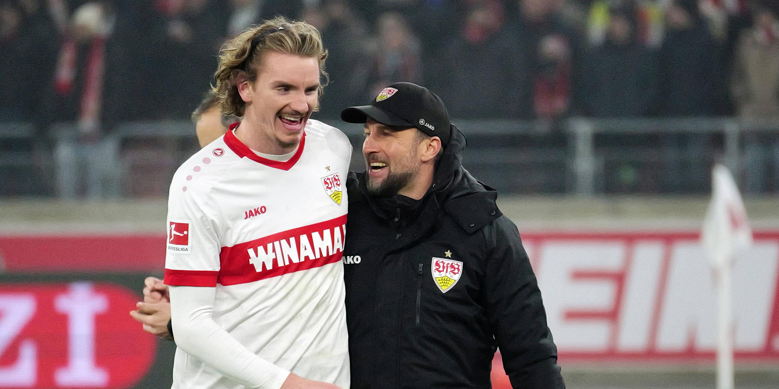 Nick Woltemade und der VfB Stuttgart Trainer Sebastian Hoeneß laufen über das Spielfeld.