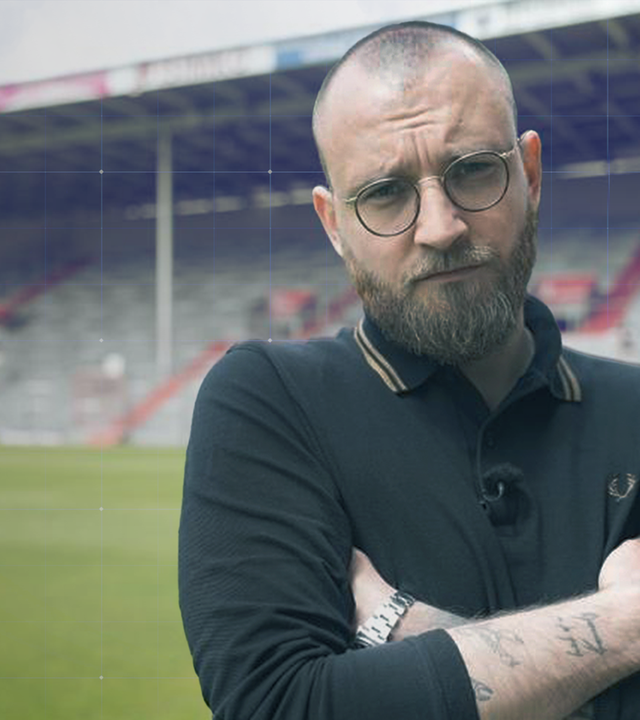 Nico Heymer mit verschränkten Armen auf dem Rasen des Fußballstadions
