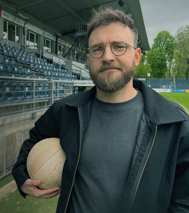 Nico Heymer mit Fußball unter dem Arm am Rand des Spielfeldes