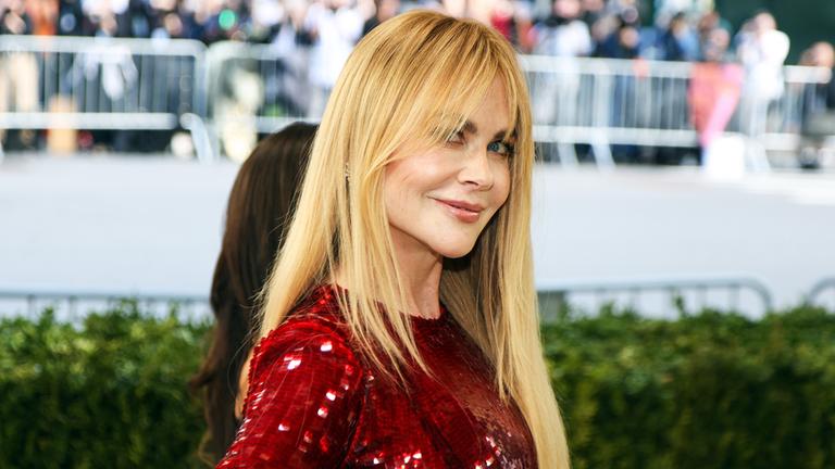 Schauspielerin Nicole Kidman posiert in einem roten Kleid auf einem Event.