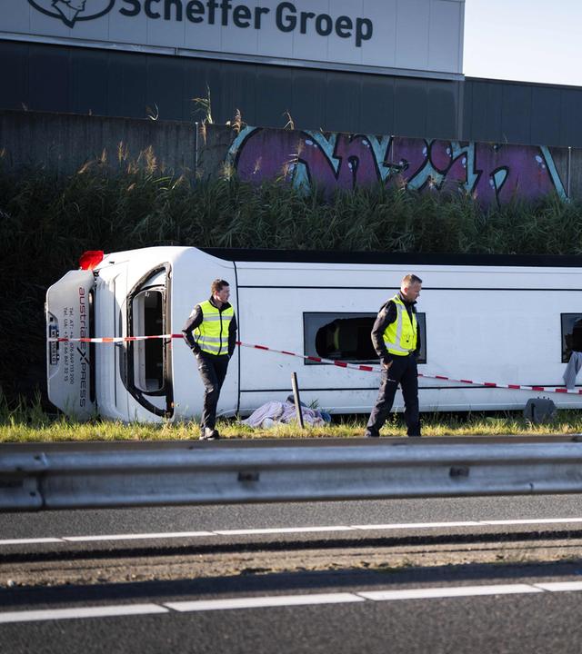 Einsatzkräfte arbeiten an der Unfallstelle auf der Autobahn A28 bei Wezep im Osten der Niederlande, wo es zu einem Zusammenstoß zwischen einem Lieferwagen und einem österreichischen Reisebus gekommen ist, bei dem mehrere Personen verletzt wurden.