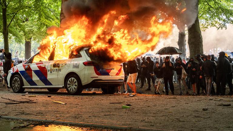 Ein Polizeiauto wird während einer Demonstration gegen die Asylpolitik in Den Haag in Brand gesetzt