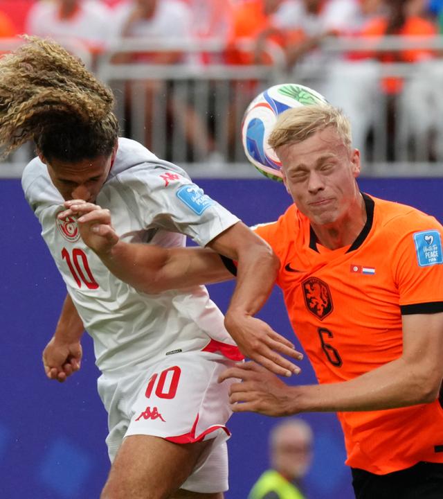Der Niederländer Jan Paul van Hecke (r.) springt gemeinsam mit dem Tunesier Hannibal Mejbri nach dem Ball