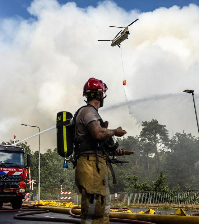 Niederlande, Oostrum: Mitglieder der Feuerwehr bekämpfen einen Waldbrand im Naturschutzgebiet Rosmolen