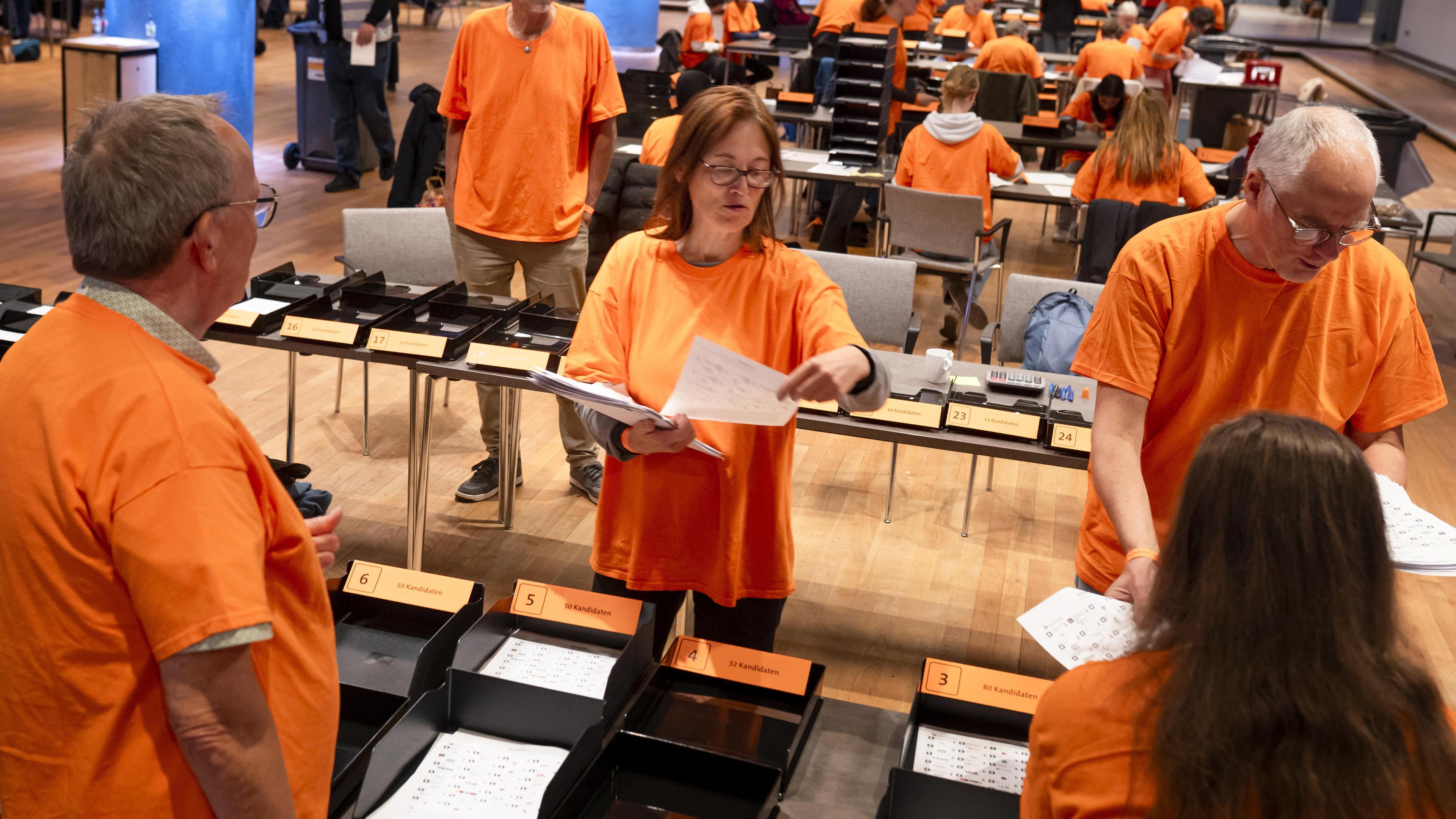 Polling station staff count postal votes from voters abroad at the World Forum in The Hague