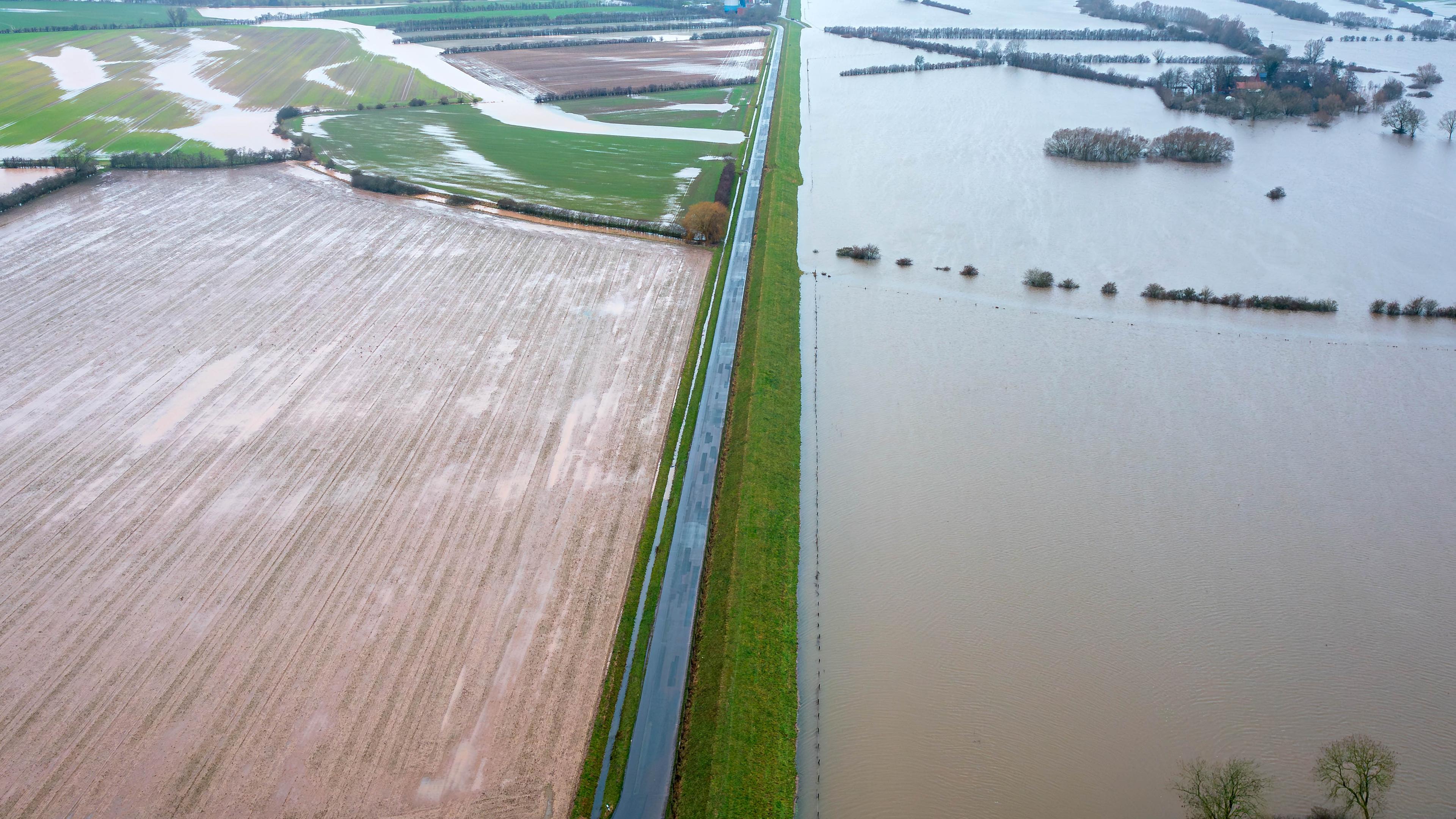 Niedersachsen, Thedinghausen: Wasser steht am für den Verkehr gesperrten Deich (Aufnahme mit Drohne). 